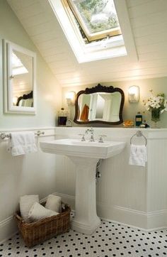 a white sink sitting under a bathroom mirror next to a window in a room with black and white tile flooring