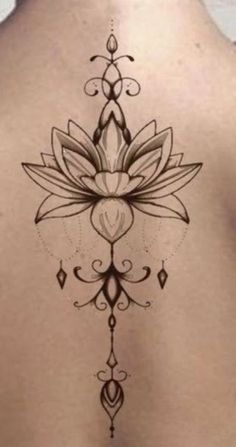 a woman's back with a lotus tattoo on it