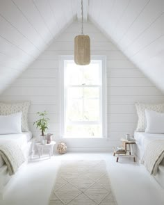 a bedroom with two beds and a rug on the floor in front of a window