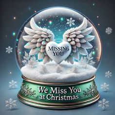 a snow globe with an angel heart in it and the words, we miss you at christmas