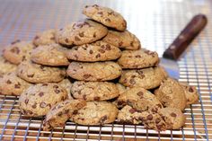 a pile of cookies sitting on top of a cooling rack next to a chocolate bar