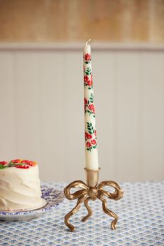 a candle is sitting next to a cake on a table