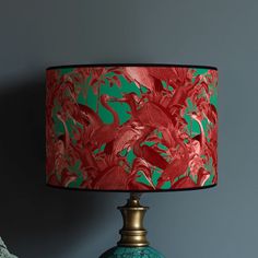 a lamp that is sitting on top of a table next to a vase with flowers