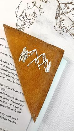 a leather bookmark with mountains and trees on it