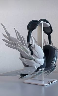 a pair of headphones sitting on top of a metal stand next to a white wall