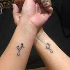 two people holding hands with tattoos on them