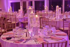 the tables are set with candles and place settings for an elegant dinner or banquet event