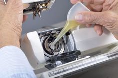 an older man is using a sewing machine to sew on something yellow or white