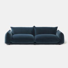 a blue couch with two pillows on it's back and one arm facing the camera