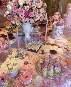 a table topped with lots of cakes and cupcakes