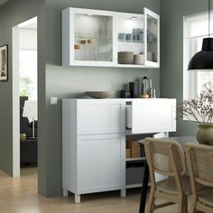 a white cabinet sitting next to a dining room table