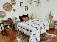 a bed in a room with many pictures on the wall and rugs around it