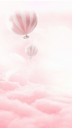 two hot air balloons flying in the sky above some clouds and pink hued water