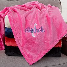 a pink blanket sitting on top of a couch