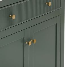 a green cabinet with brass handles and knobs on the doors is shown in this image