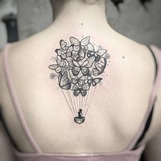 the back of a woman's neck with flowers on it and an arrow in the middle