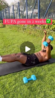 a man doing push ups on a mat with dumbbells in front of him