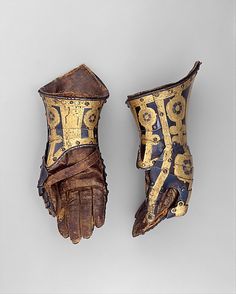 an old pair of gloves with gold designs on them