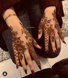 a woman's hands with henna tattoos on them