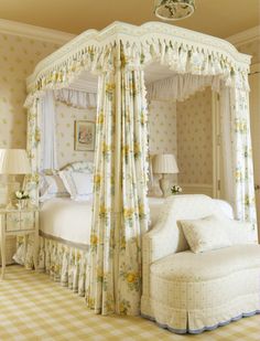 a four poster bed sitting in a bedroom next to a white dresser and lamp on top of a checkered floor