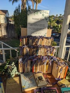 many books are stacked on top of each other in front of a sign that says thank you