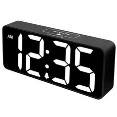 the digital clock is black and has white numbers