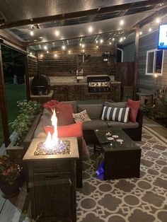 an outdoor living area with couches and fire pit