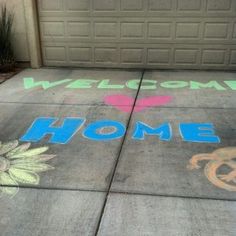 the sidewalk has been decorated with chalk and welcome home written in different colors on it