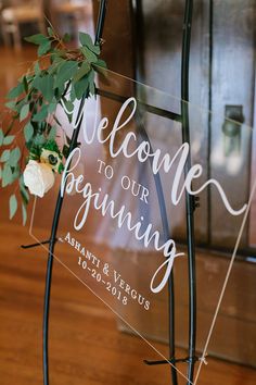 a welcome to our wedding acrylic sign with white flowers on the front and back