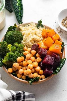 a bowl filled with rice, broccoli and chickpeas next to other foods