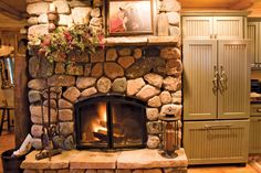 a stone fireplace in the middle of a kitchen