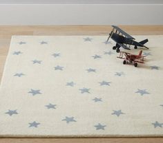 a toy airplane sitting on top of a rug in the middle of a wooden floor