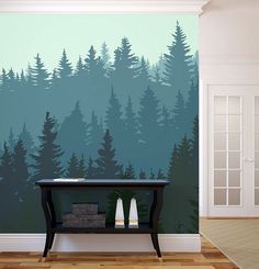 a room with a table and trees painted on the wall in front of it,