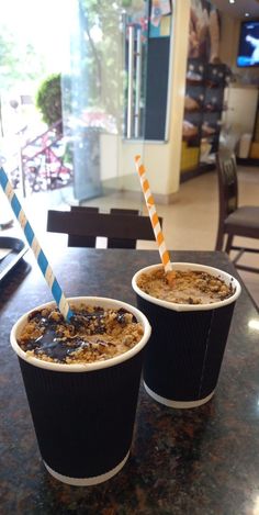 two cups filled with food sitting on top of a table