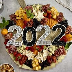 the number twenty two made out of fruits and vegetables on top of a platter