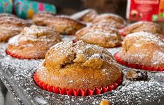 several muffins with powdered sugar on top