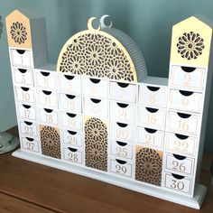 a white and gold clock sitting on top of a wooden table