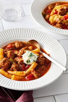 two white plates filled with pasta and meat