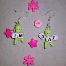 two green and pink earrings with words that say i'm gay