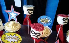 some cupcakes are decorated with red, white and blue frosting as well as superhero masks