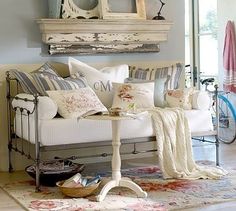 a living room filled with lots of furniture and pillows on top of a white couch