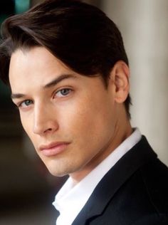 a close up of a person in a suit and tie looking off to the side