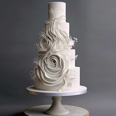 a three tiered white wedding cake with flowers on top