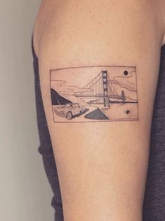 a woman's arm with a drawing of a car and bridge on it,