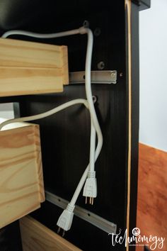 an electrical cord is plugged into the back of a cabinet