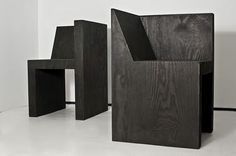 three black wooden chairs sitting on top of a white floor next to each other in front of a wall