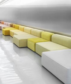 a row of different colored couches sitting next to each other in a room with white floors