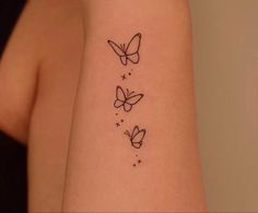 a woman's arm with three butterflies tattoo on the left side of her arm