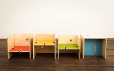 four different colored chairs sitting on top of a wooden floor