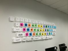 an office cubicle with computer desks and keyboard on the wall